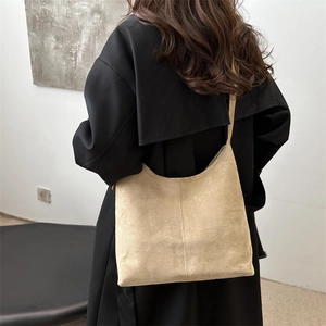 Minimalist large capacity beige faux suede tote bag worn on shoulder by model