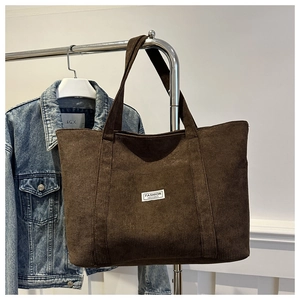Detail of coffee corduroy tote bag showing fine ribbed texture and Fashion label