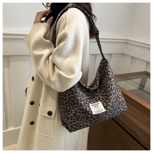 Détail d'un sac cabas en nylon léopard avec une étiquette de marque tissée blanche