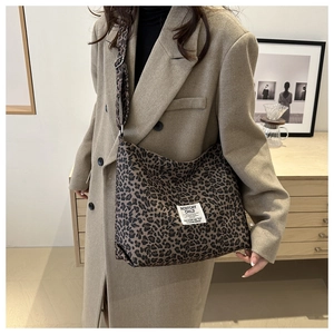 Détail d'un sac cabas léopard avec étiquette de marque et bandoulière réglable chic