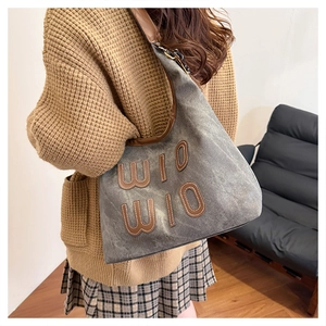 Detail of retro canvas tote bag showing dark gray washed fabric and leather WIO letters