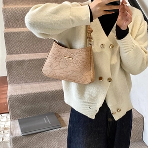 Elegant apricot lace hobo bag with metal trim shown in a stylish lifestyle setting