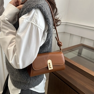 Retro brown leather baguette bag with gold buckle and twisted shoulder strap