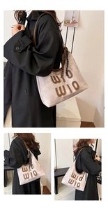 Detail of stone textured tote bag with brown leather WIO embroidery and tennis racket charm
