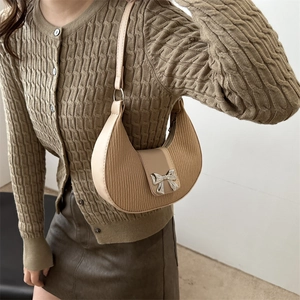 Elegant beige half-moon hobo bag with pleated texture and silver metal bow detail