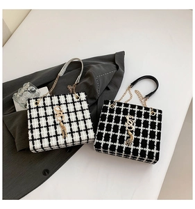 Detail of plaid tweed tote bags with gold chain straps and metallic SS logo charms