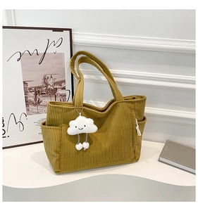 Detail of corduroy tote bag with textured stripes and a cute plush cloud pendant