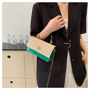 Detail of woven straw and green leather patchwork bag with golden metal ring handle