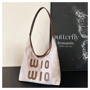 Detail of light gray hobo bag with large brown WIO WIO lettering and leather straps
