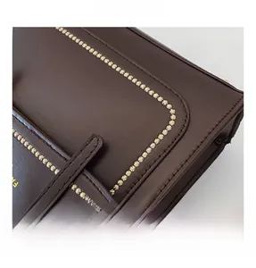 Close-up of star stitching and gold buckle on dark brown leather casual backpack