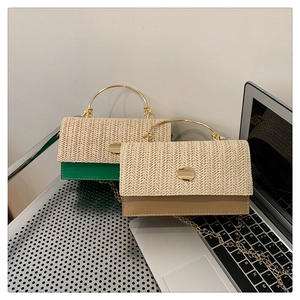 Detail of woven straw handbag featuring gold metal handle and chain strap in green and khaki