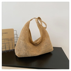 Close-up of beige woven tote bag showing detailed hollow knit pattern and leather handle
