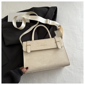 Détail d'un grand sac fourre-tout beige minimaliste avec bandoulière large et texte