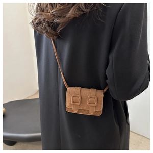 Rear view of model wearing a brown stone pattern mini crossbody bag with double buckles