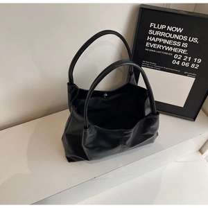 Detail view of large black minimalist tote bag with magnetic closure and top handles