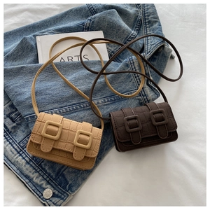 Close-up of crocodile embossed mini crossbody bags in khaki and dark brown with buckle detail