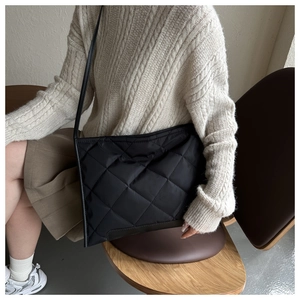 Detailaufnahme der schwarzen Stepptasche mit Rautenmuster und glatter Nylon-Struktur