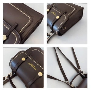 Detail of dark brown leather bag showing gold hardware and embossed fashion logo