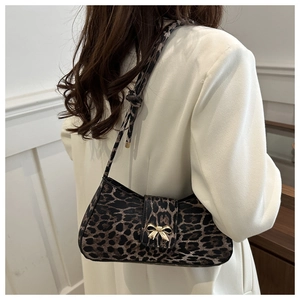 Close-up of leopard print shoulder bag featuring a decorative golden bow buckle detail