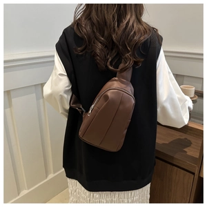 Brown matte leather chest bag with silver zipper shown from a back-wearing perspective