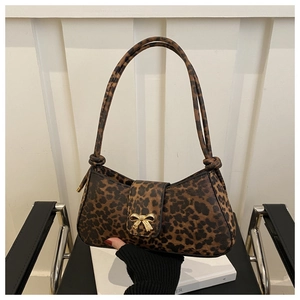 Close-up of leopard print shoulder bag featuring a decorative gold bow metal buckle