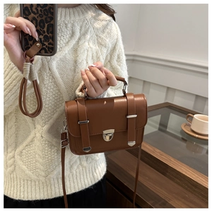 Vista dettagliata della borsa quadrata in pelle marrone con fibbia argentata al bar