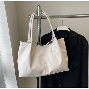 Detail of minimalist cream white tote bag with vertical stitching on textured PU leather