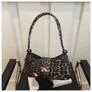 Detail of leopard print leather handbag with a golden bow-shaped metal clasp closure