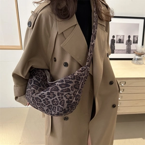 Grand sac hobo à imprimé léopard avec large bandoulière porté par un mannequin en trench