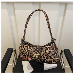 Close-up of leopard print shoulder bag featuring a golden metallic bow and textured faux leather