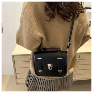 Vista posteriore di una donna con borsa a tracolla vintage nera e fibbia in metallo