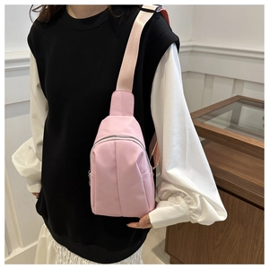 Detailed view of pink waterproof nylon crossbody bag with silver zipper and thick strap