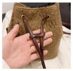 Détail du cordon de serrage sur le sac seau marron en tissu bouclé peluche
