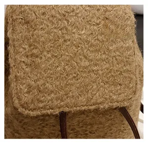 Gros plan détaillé du tissu en laine bouclée marron et de la bandoulière de ce grand sac