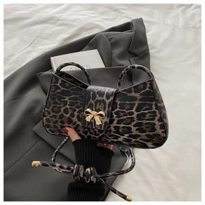 Close-up of leopard print shoulder bag with elegant golden bow-shaped magnetic clasp