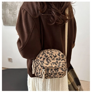 Detail showing back view of leopard print corduroy crossbody bag with beige strap