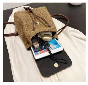 Détail de l'intérieur du sac à dos en laine contenant tablette et objets du quotidien