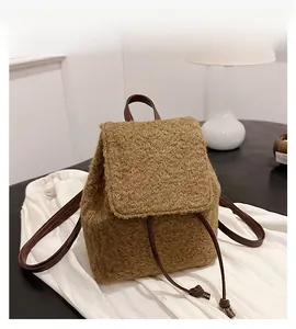 Détail du sac à dos en laine marron avec fermeture à cordon et bretelles en cuir