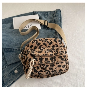 Detail of leopard print corduroy crossbody bag with woven drawstring and adjustable strap