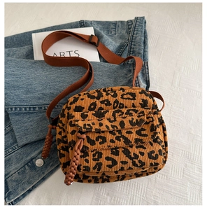Detail of leopard print corduroy crossbody bag with adjustable strap and braided zipper