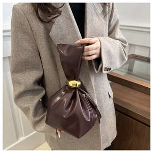 Détail du sac seau en cuir PU chocolat noir avec une poignée à boule en métal doré poli