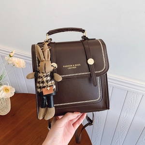 Dark brown faux leather backpack for women with rabbit pendant and gold fashion lettering
