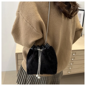 Detail der schwarzen Samt-Beuteltasche mit eleganten Perlen-Details und silberner Kette