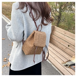 Vue latérale d'un sac à dos en laine marron avec cordon et lanières en cuir chic
