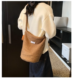 Detail view of brown teddy fleece bucket bag with Love Fashion label on fuzzy texture