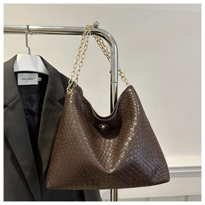 Close-up of woven brown leather tote bag featuring gold chain straps and metal twist lock