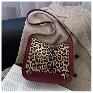 Leopard print crossbody bag with burgundy leather trim and sleek U-shaped bottom design