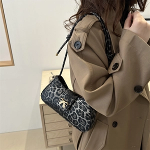 Minimalist leopard print shoulder bag with gold bow buckle on beige trench coat outfit