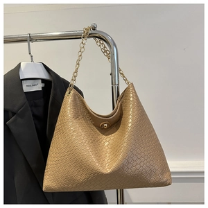 Detail view of the large brown woven texture handbag with golden chain and metal lock