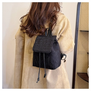 Détail de la texture en laine noire et du cordon de serrage sur un sac à dos d'hiver